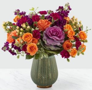 purple kale with orange flowers and magenta stock in a vase