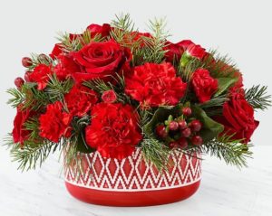 red florals and holly in vase