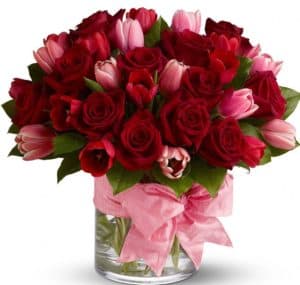 Tell someone, "I love you!" with two of nature's most beautiful blooms - fragrant crimson roses for romance, and delicate pink tulips to signify friendship and devotion. Accented with a big pink bow