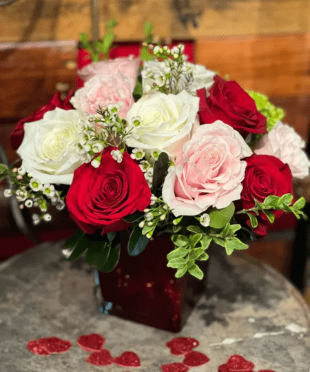 Surprise your Valentine with this romantic beauty. Mixed roses in a red mercury vase. 